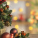Close-up of Christmas tree with colorful ornaments in the foreground and Christmas decoration blurred in the background