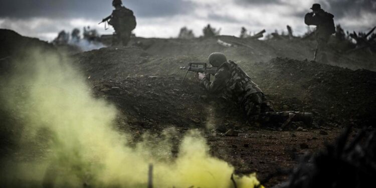 Ukrainian soldiers walk during a training exercise with French soldiers at a French military camp in France in November 2023. On their stomachs, the Ukrainian soldiers advance slowly at the edge of the forest in support of an assault group that is seizing the enemy trench: in a military camp in France, they are being trained in combat before leaving for the front. (Photo by OLIVIER CHASSIGNOLE / AFP) / EMBARGO UNTIL MONDAY NOVEMBER 13, 2023,  00.01